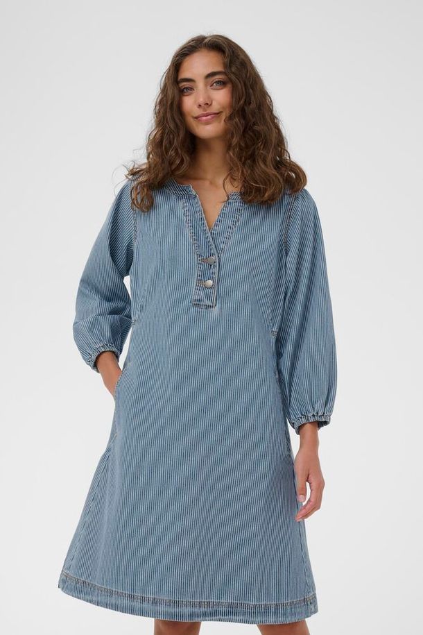 CUayna kjolen er allsidig og tidløs, i en delikat lys denim. Kjolen har 3/4 ermer, en forsiktig innsving i livet og knelengde.&nbsp;

Kjole i 80% bomull og 20% polyester.