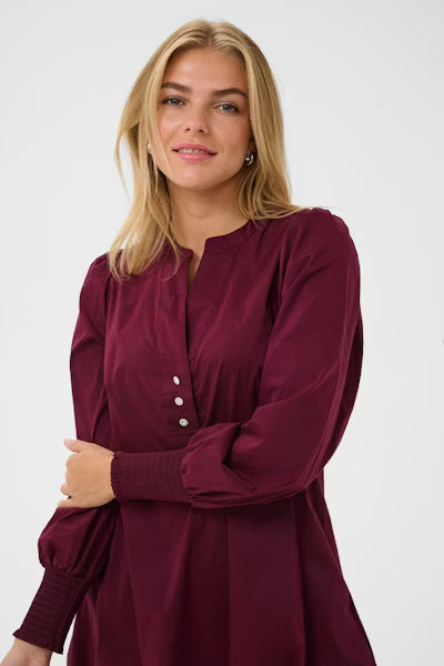 Vinrød midikjole med v-hals og knappedetaljer. Allsidig og feminin passform, perfekt til jobb eller finere anledninger.&nbsp;

Materialsammensetning: 65 % Bomull, 33 % Polyester, 2 % Elastane.