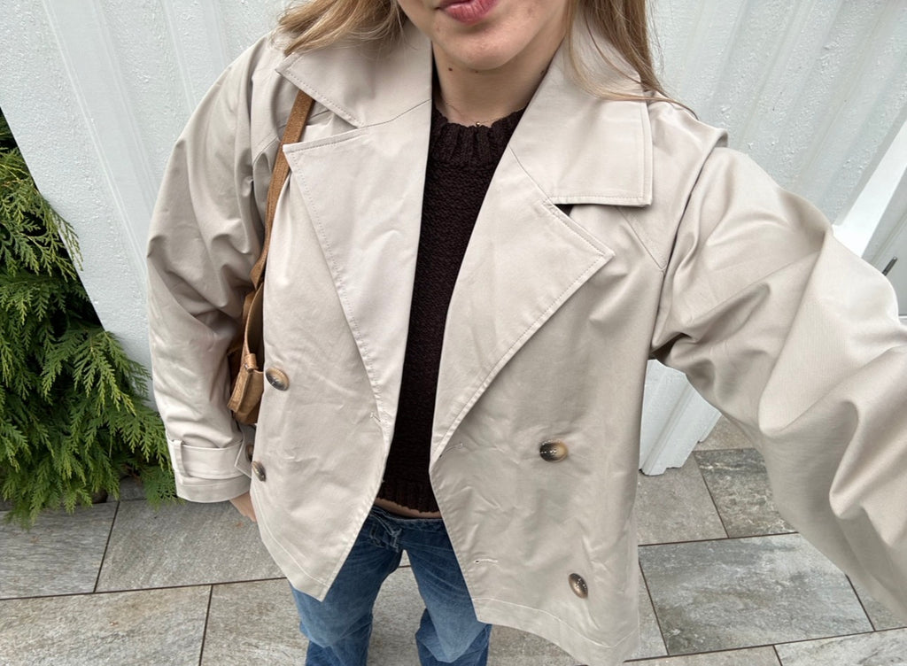 Klassisk trenchcoat er et tidløst baseplagg og et absolutt must i vårgarderoben. Denne trenchcoaten kommer i en lys beige/krem-farge med klassisk, cropped passform som gir et elegant uttrykk.&nbsp;